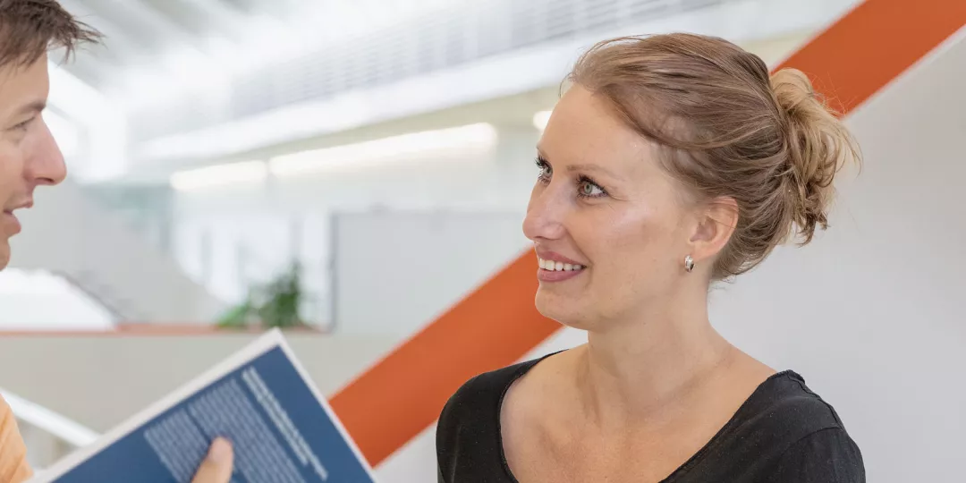 Ein Student und eine Studentin tauschen sich in den Fluren der HfH aus. 